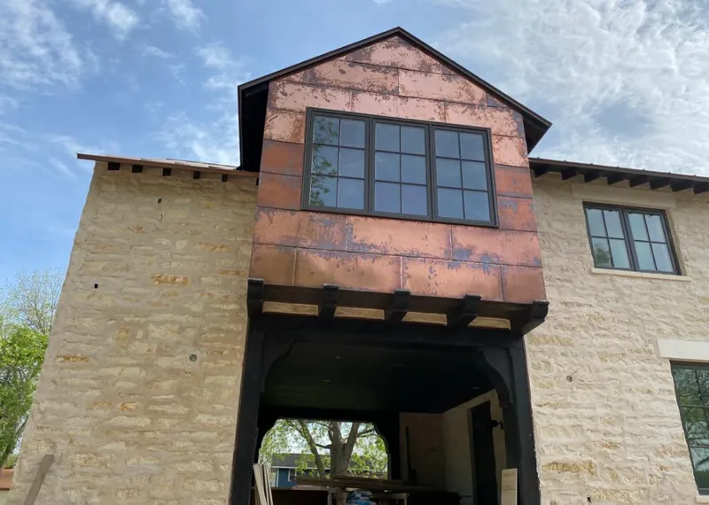 Copper metal panel facade on a stone building for Roof Repair in Gages Lake